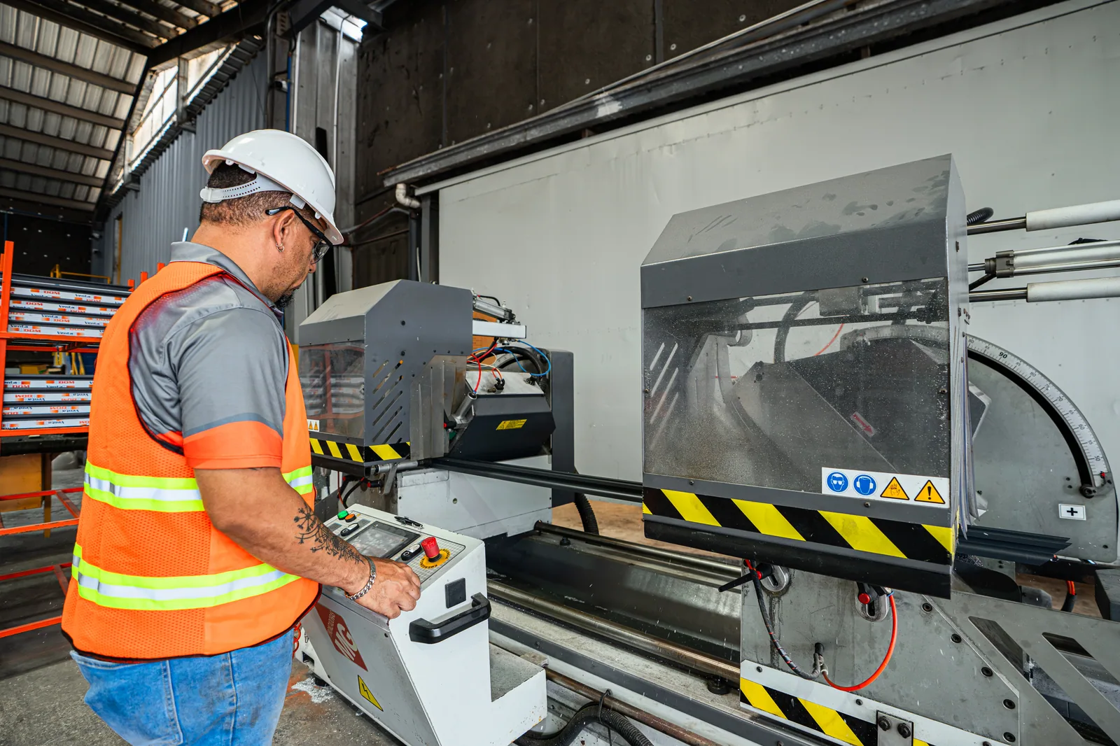 Operario controlando maquinaria de corte industrial en el taller