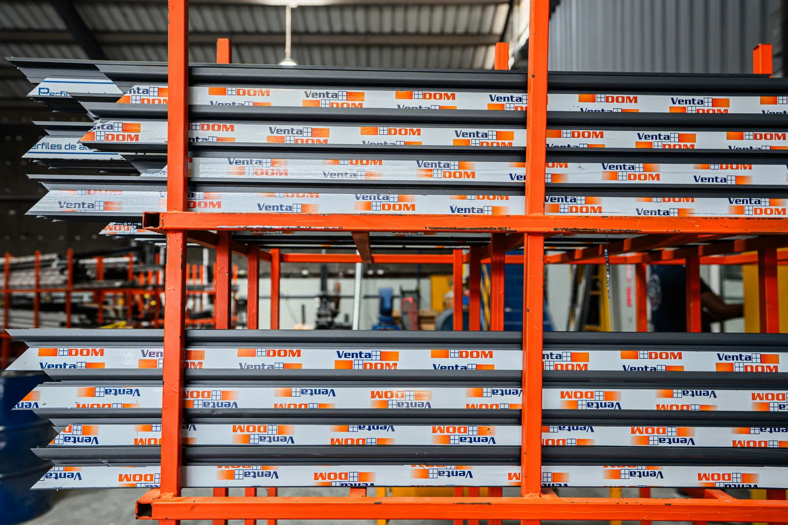 Perfiles de aluminio organizados en estanterías de producción