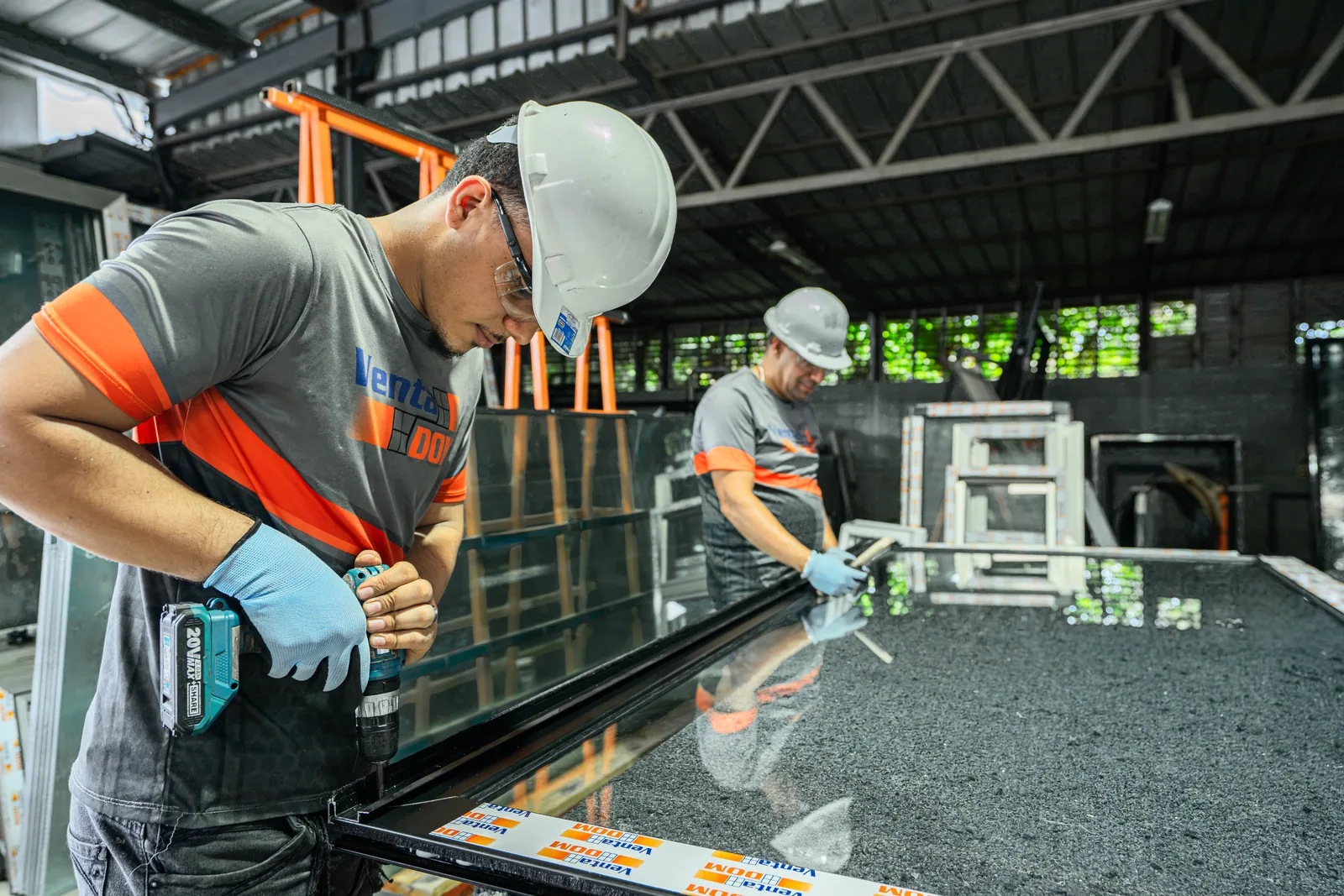 Especialistas trabajando un panel de vidrio sobre una mesa de corte