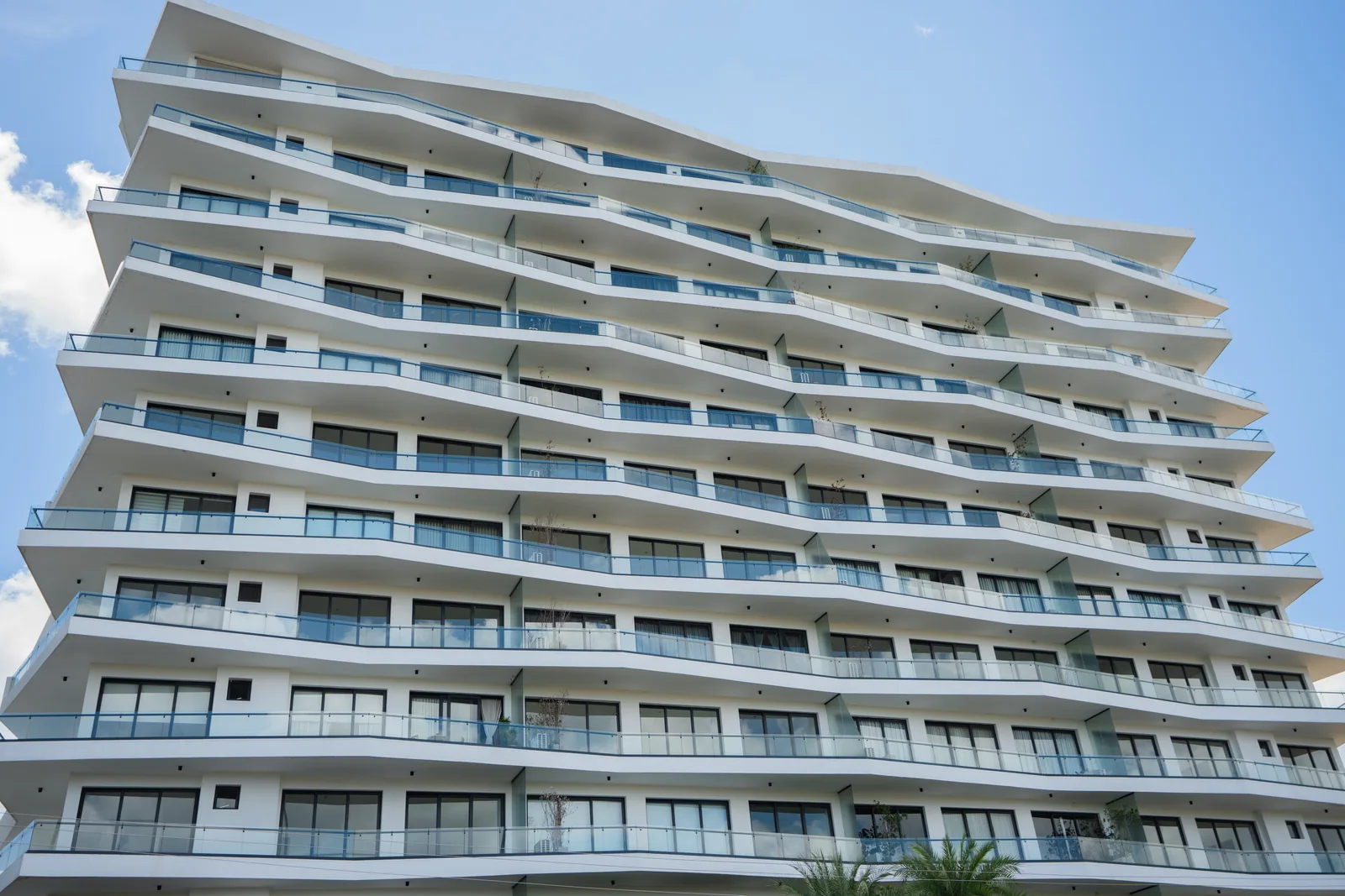 Edificio residencial con amplios ventanales y barandas de vidrio