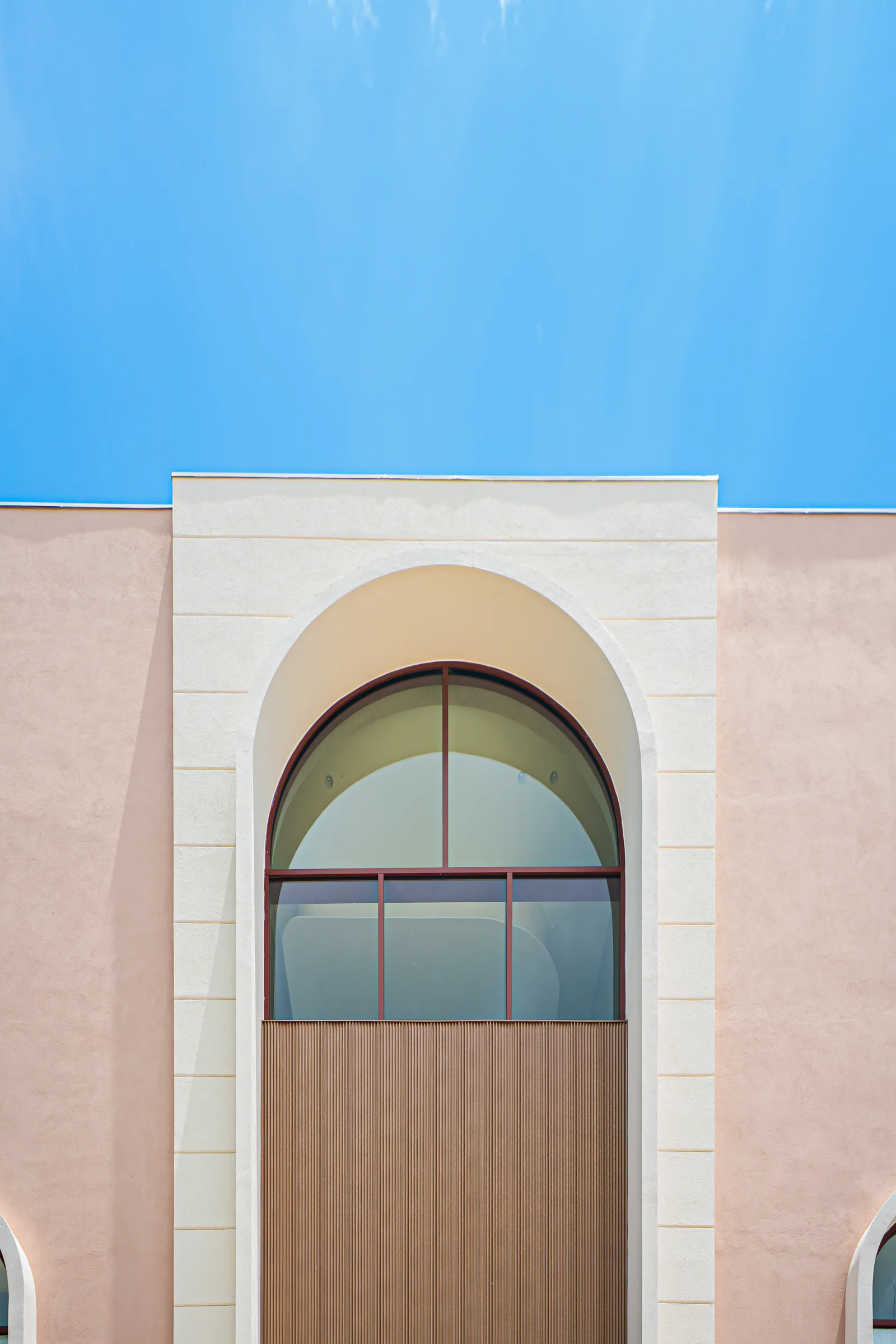 Detalle arquitectónico con ventana de arco y cielo azul