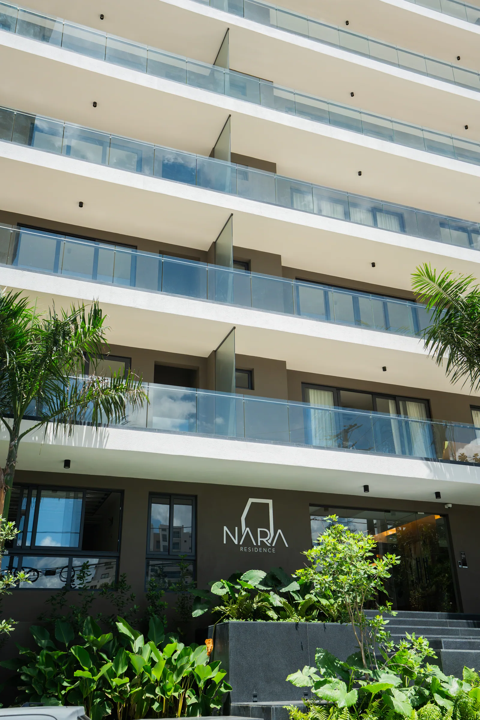 Detalle de edificio residencial con balcones y barandas de vidrio